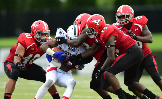 YOUNGSTOWN, OHIO - SEPTEMBER 6, 2014: Receiver Devin Rahming #7 of Duquesne is tackled by defenders Jaylin Kelly #40, Deon Hall #19, Jameel Smith #26 and D.J. Thomas #18 during the 4th quarter of Saturday afternoon game at Stambaugh Stadium. YSU won 34-23. (Photo by David Dermer/Youngstown Vindicator)