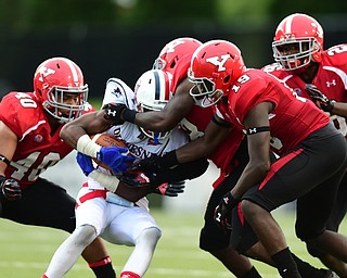 YOUNGSTOWN, OHIO - SEPTEMBER 6, 2014: Receiver Devin Rahming #7 of Duquesne is tackled by defenders Jaylin Kelly #40, Deon Hall #19, Jameel Smith #26 and D.J. Thomas #18 during the 4th quarter of Saturday afternoon game at Stambaugh Stadium. YSU won 34-23. (Photo by David Dermer/Youngstown Vindicator)