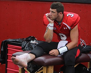 Youngstown State starting quarterback sits on the sidelines with ice on his ankle after being injured in the fourth quarter while scrambling away from Duquesne defenders during Saturday evenings matchup at Stambaugh Stadium.  Dustin Livesay  |  The Vindicator  9/6/14  Stambaugh Stadium
