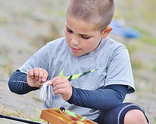 Jeff Lange | The Vindicator  R.J. Trimble (7) attaches his lure to the end of his line during the public fishing day at Meander Reservoir, Saturday morning. R.J. is the son of Ron Trimble of Youngstown.