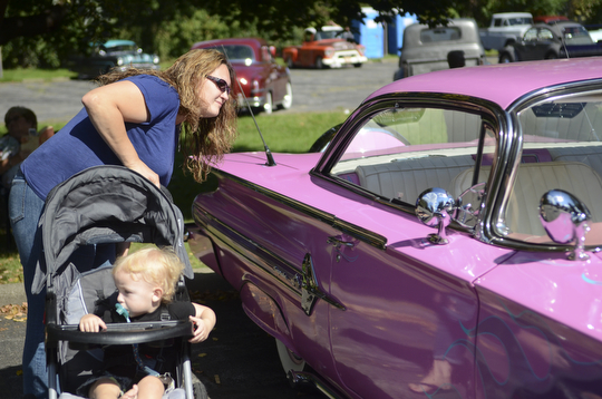 Katie Rickman | The Vindicator.Tracy Kahl of Austintown looks at the interior of a 1960 Chevy Impala as her her son Donovin Robertson, 15 months, sits in his stroller at the second annual Rust Belt car show and artist market at the B&O station September 7, 2014.
