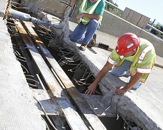        ROBERT K. YOSAY  | THE VINDICATOR..Randy Partika - Mahoning county bridge engineer and Tony Gaglione of B>G>Trucking and Construction  look at the under layment of steel where the expansion joints are being replaced.. As it undergoes its first major rehabilitation in the 31 years since it opened, work will continue on the Vietanam Veterans Memorial  bridge through November, Mahoning CountyÕs bridge engineer said..The reduction to one lane in each direction for painting and rehabilitation began July 28 and will continue through November...  .....  -30-