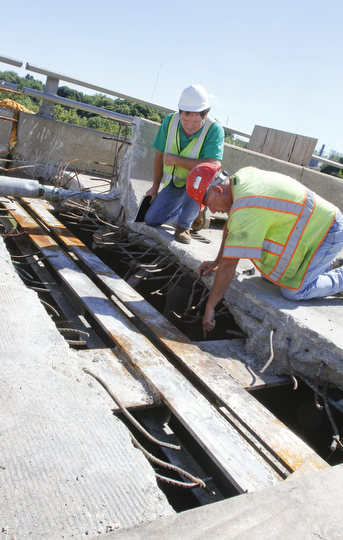        ROBERT K. YOSAY  | THE VINDICATOR..Randy Partika - Mahoning county bridge engineer and Tony Gaglione of B>G>Trucking and Construction  look at the under layment of steel where the expansion joints are being replaced.. As it undergoes its first major rehabilitation in the 31 years since it opened, work will continue on the Vietanam Veterans Memorial  bridge through November, Mahoning CountyÕs bridge engineer said..The reduction to one lane in each direction for painting and rehabilitation began July 28 and will continue through November...  .....  -30-