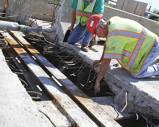        ROBERT K. YOSAY  | THE VINDICATOR..Randy Partika - Mahoning county bridge engineer and Tony Gaglione of B>G>Trucking and Construction  look at the under layment of steel where the expansion joints are being replaced.. As it undergoes its first major rehabilitation in the 31 years since it opened, work will continue on the Vietanam Veterans Memorial  bridge through November, Mahoning CountyÕs bridge engineer said..The reduction to one lane in each direction for painting and rehabilitation began July 28 and will continue through November...  .....  -30-