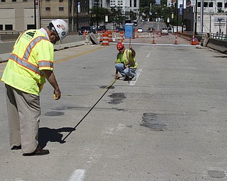        ROBERT K. YOSAY  | THE VINDICATOR..Measuring  surface areas to be replaced is Dennis Gertko and Tony Gaglione of B>G>Trucking and Construction  look at the under layment of steel where the expansion joints are being replaced.. As it undergoes its first major rehabilitation in the 31 years since it opened, work will continue on the Vietanam Veterans Memorial  bridge through November, Mahoning CountyÕs bridge engineer said..The reduction to one lane in each direction for painting and rehabilitation began July 28 and will continue through November...  .....  -30-