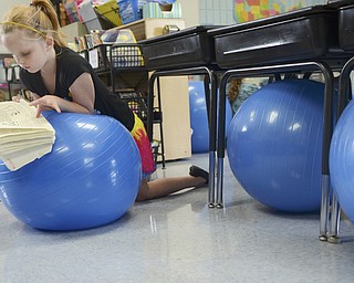 Katie Rickman | The Vindicator.Chasity Messenger, 8, of North Jackson leans on a medicine ball while reading at Jackson-Milton Elementary School Tuesday, Sept. 9, 2014.