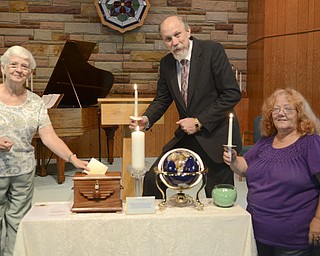 Katie Rickman | The Vindicator.Lynn Denning, left, of Cortland holds a prayer card above a prayer box as Rev. Ric Schumacher and Lyda Couch of Niles Tuesday, Sept. 9, 2014.