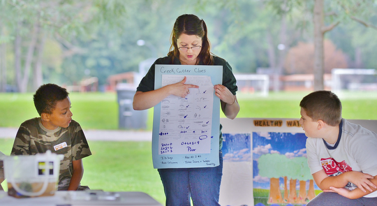 Jeff Lange | The Vindicator  Amy Reeher of the Trumbull Soil & Water Conservation District teaches a group of kids from Willard and McGuffey Elementary schools how to determine the quality of a water source by the type and number of creatures living in it, Tuesday morning at Perkins Park in Warren.