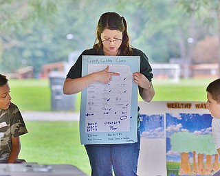 Jeff Lange | The Vindicator  Amy Reeher of the Trumbull Soil & Water Conservation District teaches a group of kids from Willard and McGuffey Elementary schools how to determine the quality of a water source by the type and number of creatures living in it, Tuesday morning at Perkins Park in Warren.