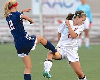 Jeff Lange | The Vindicator  Fitch's Brittany McFall (left) kicks the ball over Haylee Klacik as she ducks, Monday night in Canfield.