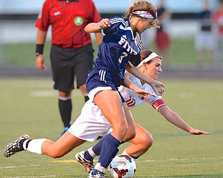 Jeff Lange | The Vindicator  Austintown Fitch's Maia Totterdale fights for possession of the ball with Canfield senior captain Sydney Miller as she topples to the ground, Monday night in Canfield.