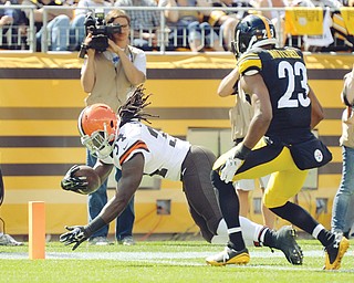 Cleveland Browns running back Isaiah Crowell (34) dives past Pittsburgh Steelers free safety Mike Mitchell (23) for a touchdown in the third quarter of the NFL football game on Sunday, Sept. 7, 2014 in Pittsburgh.
