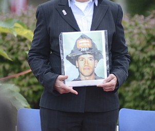Katie Rickman | The Vindicator.Lisa Kleinhandler of Canfield holds a photo of Michael Kiefer, a New York City firefighter who died while responding to the attacks on the World Trade Center 13 years ago. Kleinhandler spoked at the anniversary ceremony Thursday, Sept. 11, 2014.