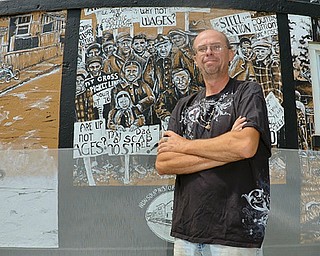 Tim Sokoloff , president of the Iron Soup Historical Preservation Company, stands in front of the mural on the side of 13 Delmar Ave. in Campbell. The mural was painted last month by artist Katelyn Gould, a city native who now lives in Pittsburgh.