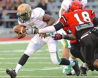 Jeff Lange | The Vindicator  Ursuline running back Kimauni Johnson struggles to keep a grip on the ball as he rushes toward the end zone into the defense of Ma'Lik Richmond in the first quarter of their Friday night contest at Harding Stadium.