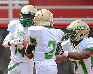 Jeff Lange | The Vindicator  Ursuline's Dakota Hobbs (left) celebrates his return that resulted in an Irish touchdown in the first quarter against Big Red with teammates Anise Algahmee (2) and Tre Spinks.