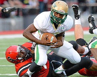 Jeff Lange | The Vindicator  After rushing for a gain of 5 in the first quarter, Ursuline's Kimauni Johnson is brought down by Steubenville defender Ma'Lik Richmond in the first quarter of Friday night's game in Steubenville.