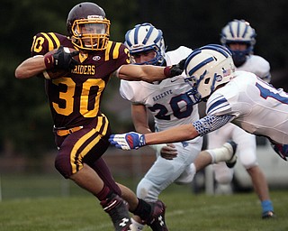  .          ROBERT  K. YOSAY | THE VINDICATOR..Joseph Alessi #30 stiff arms #15 WesternReserve  Tim Coler  as he makes a first down during first quarter action behind them is WR #20 Brian Benyo..Western Reserve at South Range Stadium...-30-