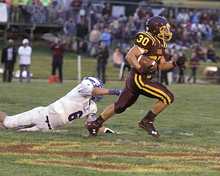  .          ROBERT  K. YOSAY | THE VINDICATOR..And he's off as  Raiders #30 Joseph Alessi breaks the last tackle Reserves  #6 John Clegg   Alessi ran about 60 yards for a TD..Western Reserve at South Range Stadium...-30-