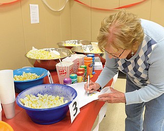 Evelyn Myers of Girard writes down flavors of popcorn for a taste test during Popcorn Fest at the Girard Multigenerational Center. Tuesday’s luncheon was one of two the center has each month.