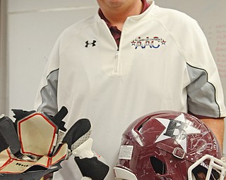 Katie Rickman | The Vindicator.Boardman High School football Assistant Athletic Director Nick Hewko poses for a photo holding a helmet and a Riddell helmet liner. Boardman High School football team is now using the Riddell Impact Response System which will allow coaches to monitor players impact on field during practices and games on Wednesday, Sept. 17, 2014 at Boardman High School.