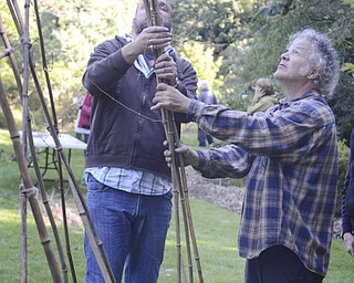 Katie Rickman | The Vindicator.Local sculptor Tony Armeni, on right, looks up at the bamboo as John Noga holds it in place at Fellows Riverside Garden on Wednesday, Sept. 17, 2014.