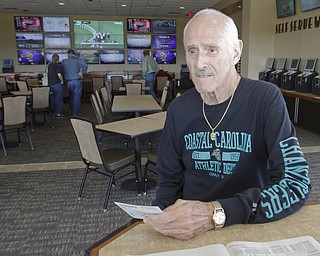        ROBERT K. YOSAY  | THE VINDICATOR..  Robert Kanotz.. from west side of Youngstown .. checks over a racing program in the wagering area.. Opening DAY  at the Austintown Hollywood Gaming as Ray 'BOOM-BOOM' Mancini was the high light of the ribbon cutting... -30-