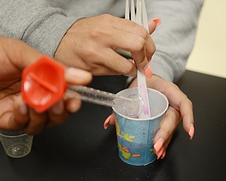 Katie Rickman | The Vindicator .Ashley Delgado, 17, of Youngstown mixes Borax, glue and water to create “slime” in a STEM class at Chaney High School on Thursday, Sept. 18, 2014 in Youngstown, Ohio.  The STEM program at Chaney has earned their third Governor’s award for STEM.