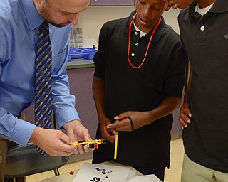 Katie Rickman | The Vindicator .Ryan Witkoski, left, helps his 8th grade students Michael Douglas, 13 (center) and Justin Young, 13, put together bicycles made out of Legos in a STEM class at Chaney High School on Thursday, Sept. 18, 2014 in Youngstown, Ohio.  The STEM program at Chaney has earned their third Governor’s award for STEM.