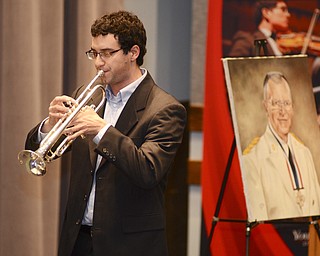 Katie Rickman | The Vindicator.Dan Honeycutt, a graduate student at YSU, plays his trumpet next to a portrait of Donald Hurrelbrink at the scholarship announcement Friday, Sept. 19, 2014.