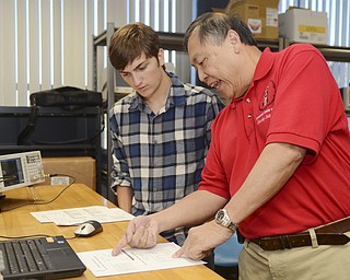 Katie Rickman | The Vindicator.Joe Weetman, a Poland High School senior, listens as Professor Kin Moy shows him an equation in an electrical engineering technology lab at YSU Friday, Sept. 19, 2014. Weetman is one of a small group of high school students who are spending the day at YSU as college students, attending classes and labs.