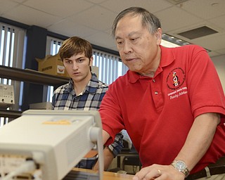 Katie Rickman | The Vindicator.Joe Weetman, a Poland High School senior, listens as Professor Kin Moy explains how things work in an electrical engineering technology lab at YSU Friday, Sept. 19, 2014. Weetman is one of a small group of high school students who are spending the day at YSU as college students, attending classes and labs.