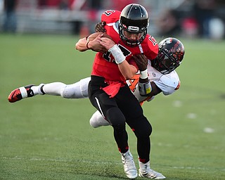 CANFIELD, OHIO - SEPTEMBER 19, 2014: Quarterback Aaron Jenkins #17 of Canfield runs the football while being tackled by defensive back Jaquore Marrs #4 of Howland during the 1st half of Friday nights OHSAA football game at Canfield High School. (Photo by David Dermer/Youngstown Vindicator)