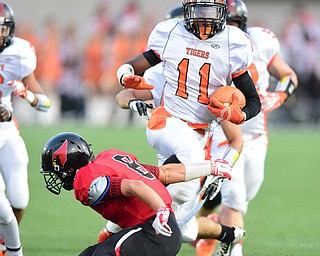 CANFIELD, OHIO - SEPTEMBER 19, 2014: Running back Tyriq Ellis #11 of Howland side steps a arm tackle from defensive back Matt Milligan #8 of Canfield during the 1st half of Friday nights OHSAA football game at Canfield High School. (Photo by David Dermer/Youngstown Vindicator)