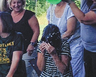 On the second day of school, teachers and staff of Holy Family School in Poland participated in the ALS Ice Bucket Challenge. The challenge came from Mandy Sinchak, a kindergarten teacher. Several staff members from the elementary and middle schools took the challenge. Shari Sfara, center, a second-grade teacher, was dumped on by Lissa Oslin, also a second-grade teacher. Marilyn Hammerton, fifth-grade teacher, watches with amusement. The teachers and staff raised more than $350 to be given to Christine Terlesky, a retired Boardman teacher with ALS. During the school year last year, Holy Family School raised more than $1,000 for Terlesky. SPECIAL TO THE VINDICATOR