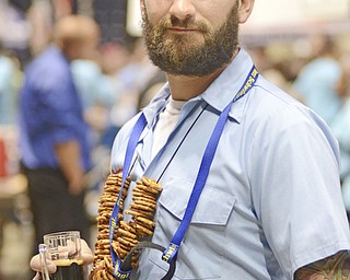 Katie Rickman | The Vindicator.Ian McMurray of Struthers wears pretzels around his neck and tastes beer at the second year of Beer Fest at The Covelli Centre, Saturday, Sept. 20, 2014.  McMurray wanted to bring the "small pub" feel to the festival and decided bring along pretzel necklaces that he and his friends wore.