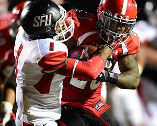 YOUNGSTOWN, OHIO - SEPTEMBER 20, 2014: Running back Martin Ruiz #29 of YSU runs through defensive back Lorenzo Jerome #1 of Saint Francis on his way ingot he end zone for a touchdown during the 1st half of Saturday nights game NCAA football at Stambaugh Stadium. (Photo by David Dermer/Youngstown Vindicator)
