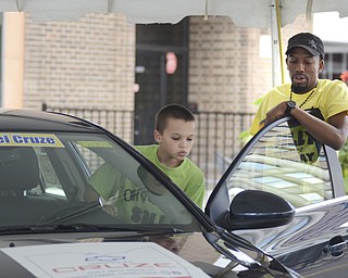 Katie Rickman | The Vindicator.Jakob Peters, 13, of Boardman looks at the new Diesel Cruze as Mayon Maxey of GM explains how the new car runs at Silly Science Sunday downtown Youngstown on Sunday, Sept. 21, 2014.