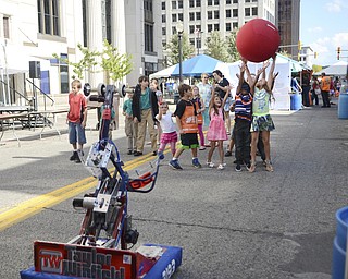 Katie Rickman | The Vindicator.A group of kids throw their hands in the air as they try to catch a ball that a robot from the  Austintown High School robotics team at Silly Science Sunday downtown Youngstown on Sunday, Sept. 21, 2014.