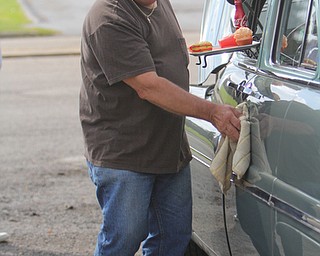 Cyril Kovach of Youngstown wipes down his 1949 Mercury during the Cops Car Show in the Struthers Plaza in Struthers on Sunday afternoon.  Dustin Livesay  |  The Vindicator  09/21/14  Struthers Plaza.