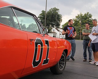 Michael Macias (left) of Lowellville talks about the work done to make a replica of the "General Lee" with Al Durbin (middle) of Lowellville and Jeff Dunn of Youngstown during the Cops Car Show in the Struthers Plaza in Struthers on Sunday afternoon.  Dustin Livesay  |  The Vindicator  09/21/14  Struthers Plaza.