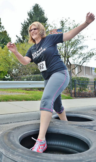 Jeff Lange | The Vindicator  Josie Hale of Boardman winces as she hops through the semi tire challenge, Sunday morning in the streets of Youngstown during the 1st annual Steelathon 5K race.