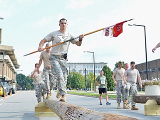 Jeff Lange | The Vindicator  Jared Hideg (center) carries the YSU Rangers guidon as he leads the YSU Army ROTC unit across the balance beams during Sunday's 1st annual Steelathon held in Youngstown.