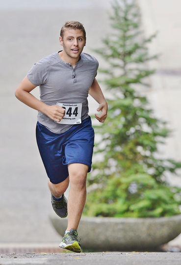 Jeff Lange | The Vindicator  Matthew Melito third place runner out of Youngstown climbs the first hill with ease in the streets of Youngstown during the 1st annual Steelathon, Sunday.