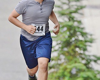 Jeff Lange | The Vindicator  Matthew Melito third place runner out of Youngstown climbs the first hill with ease in the streets of Youngstown during the 1st annual Steelathon, Sunday.