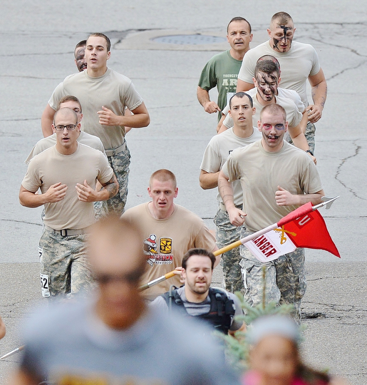 Jeff Lange | The Vindicator  Members of the YSU Army ROTC unit begin their assault on the uphill portion of the Steelathon, Sunday morning in Youngstown.