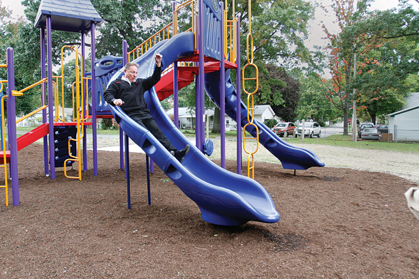 Struthers Mayor Terry Stocker tries out a newly installed sliding board at the city’s Mauthe Park. The playground equipment was installed last week, thanks in part to funding from the Ohio Department of Natural Resource’s NatureWorks grant program.