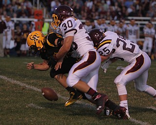 South Range's Nick Stanton (25) and Joe Alessi (30) force a fumble by Crestview's Zach Hicks (34) during the first quarter of Friday nights matchup at Crestview High School in Columbiana.   Dustin Livesay  |  The Vindicator  09/26/14  Crestview High School.