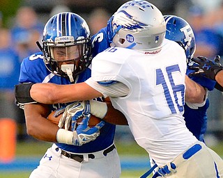 Jeff Lange | The Vindicator  Poland running back Marlon Ramirez (left) rushes as he's tackled by Eagles' defensive back Ethan Wassil during first quarter action at Dave Pavlansky Field, Friday night.