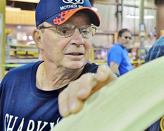 Jim Harmon of Canfield studies a wooden window frame that was made during a tour of the shop at Saturday's Red, White and True Festival held at Baird Brothers.